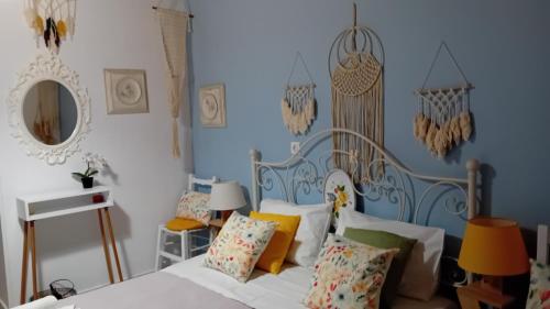 una camera con un letto bianco e una parete blu di Studio Despoina a Skala Kallonis