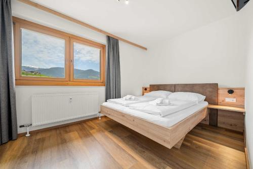 um quarto com uma cama e uma janela em Luxus Apartment Kaprun View em Kaprun