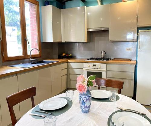 eine Küche mit einem Tisch mit einer Vase mit einer Blume darauf in der Unterkunft Appartement/maison avec jardin in Noisy-le-Sec