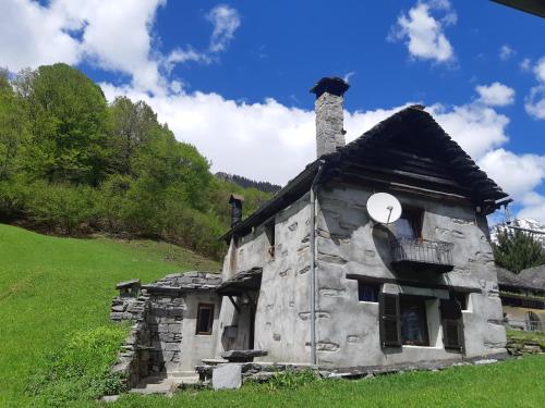 an old stone house with a chimney on a hill at Rustico Rosso di Ribia 