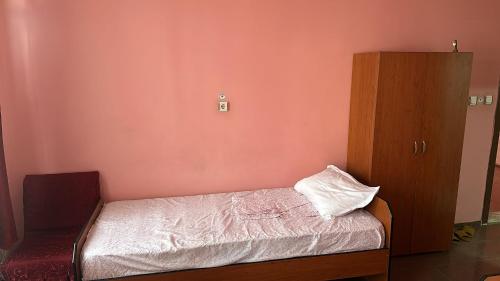 1 dormitorio pequeño con 1 cama y armario de madera en S OTEL SİVAS, en Sivas