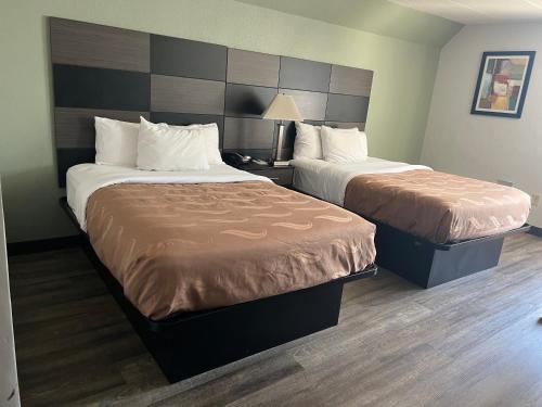 a hotel room with two beds and a lamp at Quality Inn & Suites in Cincinnati