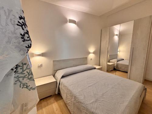 een kleine slaapkamer met een bed en een spiegel bij TuscanyAnnerelax in Cecina