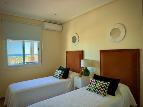 a bedroom with two beds and a window with the ocean at Hestía Vera Thalassa SPA Tu hogar lejos de casa in Vera
