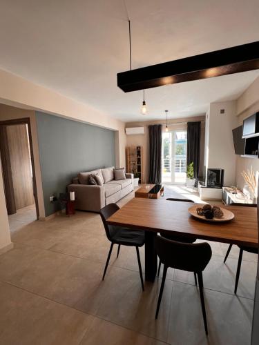 un salon avec une table, des chaises et un canapé dans l'établissement Phils Apartments II, à Leucade