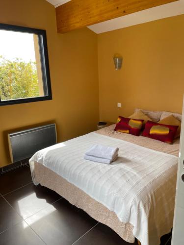 a bedroom with a large bed and a window at Chambre dans le jardin et sa SDB indépendante in Colonzelle