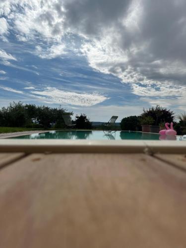 Blick auf einen Pool mit wolkigem Himmel in der Unterkunft Chambre dans le jardin et sa SDB indépendante in Colonzelle