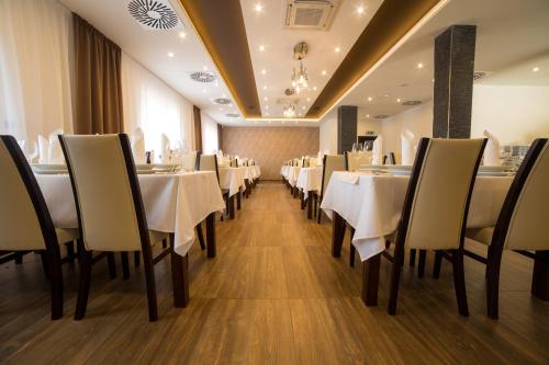 a dining room with white tables and chairs at Hotel DARO in Banská Štiavnica