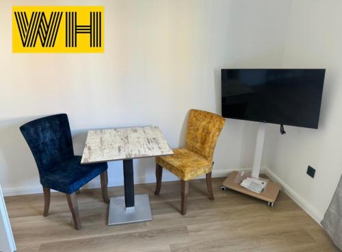 a room with a table and two chairs and a tv at Wohnung mit 4 Betten KÖ1 in Hannover