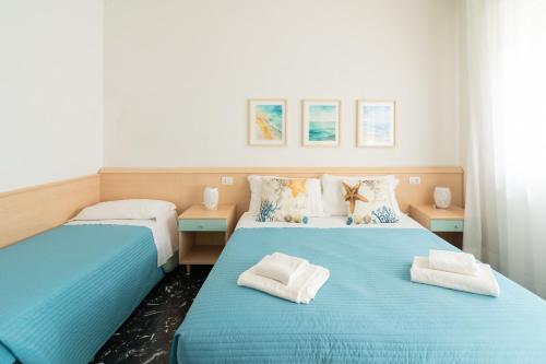 2 camas en una habitación de color azul y blanco en Residence Rex, en Chioggia