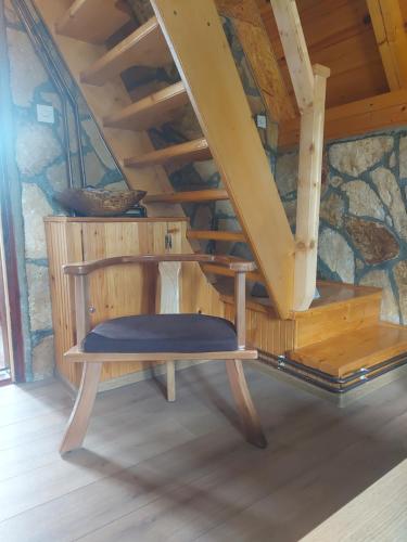 a wooden bench in a room with a staircase at Durmitor Bungalows in Žabljak