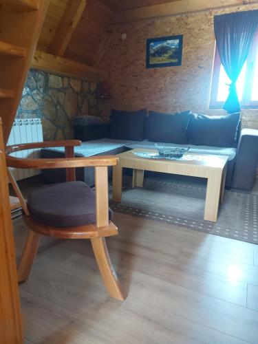 Habitación con sofá, mesa y silla en Durmitor Bungalows, en Žabljak