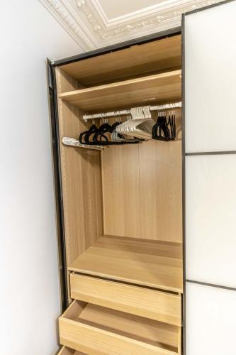 - un dressing avec des étagères en bois dans l'établissement LEDION PARIS 14, à Paris