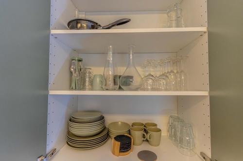 un garde-manger avec des assiettes, des tasses et des verres dans l'établissement LEDION PARIS 14, à Paris