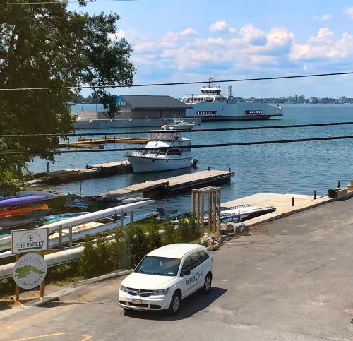 a white car parked next to a dock with boats at Hotel Wolfe Island in Marysville