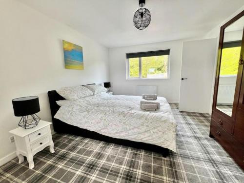 una camera con un grande letto e un comodino di Cosy Country House in Deeside a Finzean