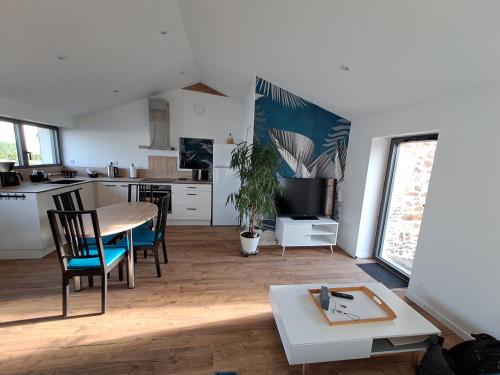 un salon avec une table et des chaises et une cuisine dans l'établissement Maison centre-bourg Belleville, à Belleville-sur-Vie