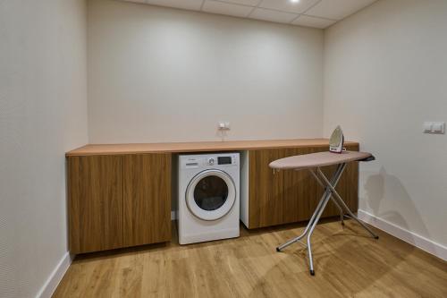 a washing machine in a room with a table at SkyHotelGwarna in Legnica