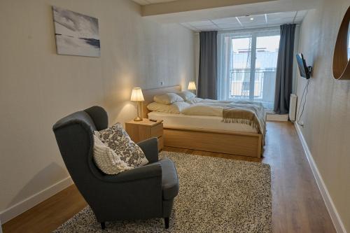 1 dormitorio con 1 cama, 1 silla y 1 silla en SkyHotelGwarna, en Legnica