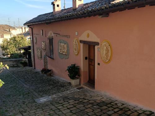 een oranje gebouw met een deur in een straat bij La Corte Alta in Fossombrone
