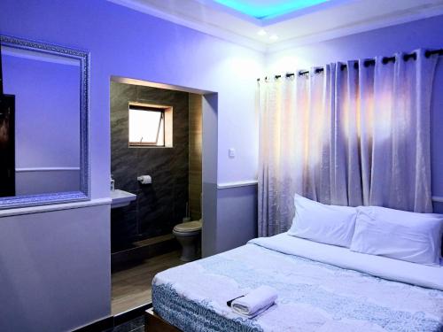 Schlafzimmer mit einem Bett, einem WC und einem Spiegel in der Unterkunft FourPoints Lodge in Lilongwe