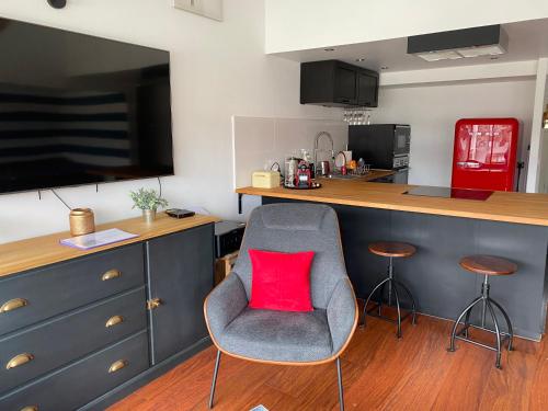 une cuisine avec une chaise avec un coussin rouge dessus dans l'établissement La Marina du bonheur, à Deauville