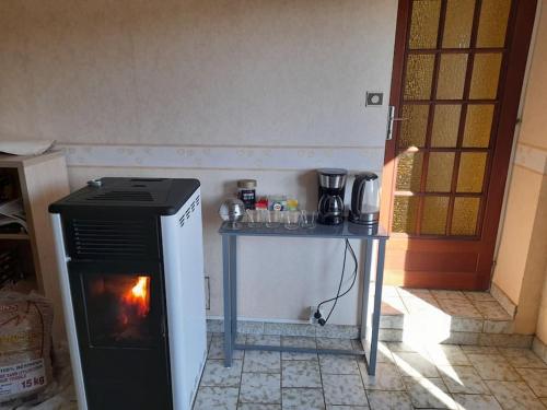 a kitchen with a stove and a table in front of it at Jolie longère au calme proche du Futuroscope in Saint-Georges-lès-Baillargeaux