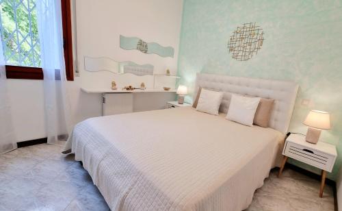 una camera da letto con un grande letto bianco con due lampade di Cappuccini Appartments a Peschiera del Garda
