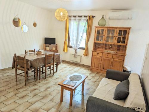 sala de estar con mesa y sofá en Village de gites Le Frigoulet, en Balazuc