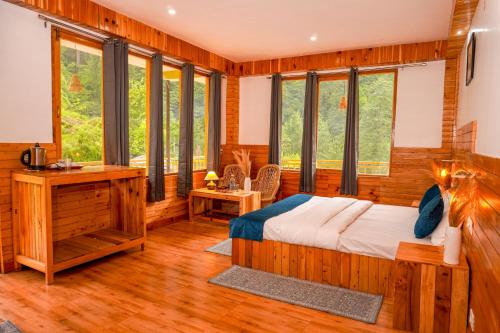 a bedroom with a bed and some windows at Odin Hostel Jibhi in Jibhi