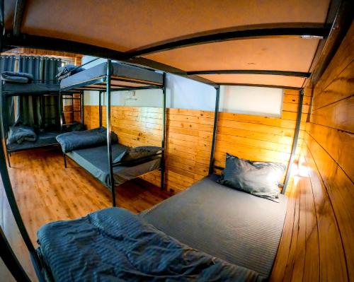 an overhead view of a room with a bed and bunk beds at Odin Hostel Jibhi in Jibhi