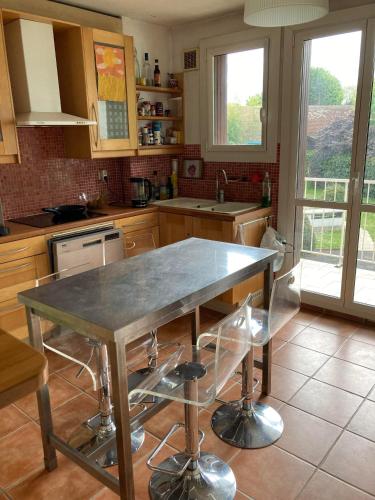 une cuisine avec une table et des chaises dans l'établissement Appartement dans le Parc, à Maisons-Laffitte