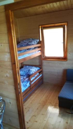 a room with three bunk beds in a cabin at Domki na Wzgórzu in Ryn