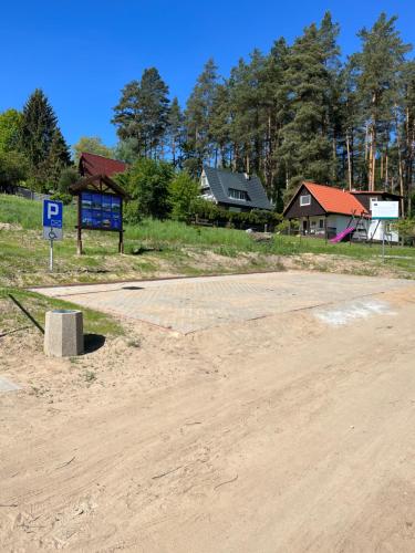 a dirt road with a parking sign and houses at Dom Przy Lesie na Warmii in Woryty