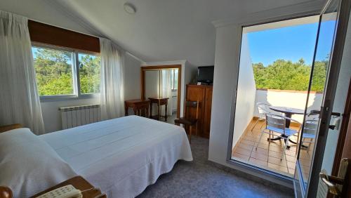 sypialnia z łóżkiem i widokiem na balkon w obiekcie Hotel La Costera w mieście A Lanzada