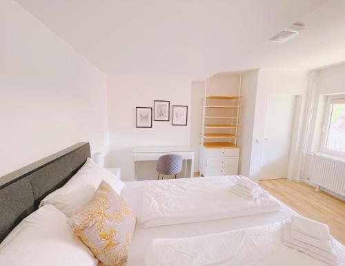 a white bedroom with a bed and a desk at StayHere Central City Studio 14 - contactless Self-Check-IN in Graz