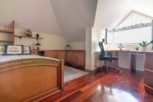 a bedroom with a bed and a desk and a chair at Villa entre Santander y Cabárceno con piscina in Revilla de Camargo