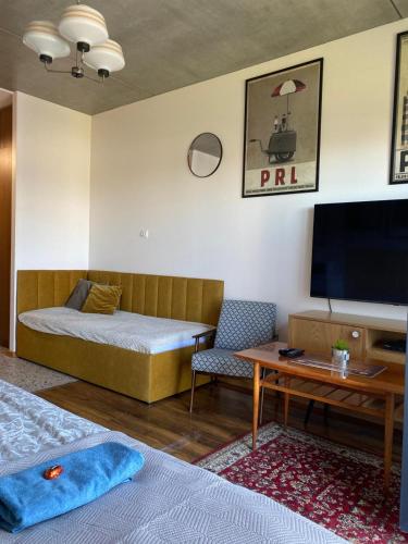 a room with a bed and a table and a tv at Lux Lotnisko in Wrocław