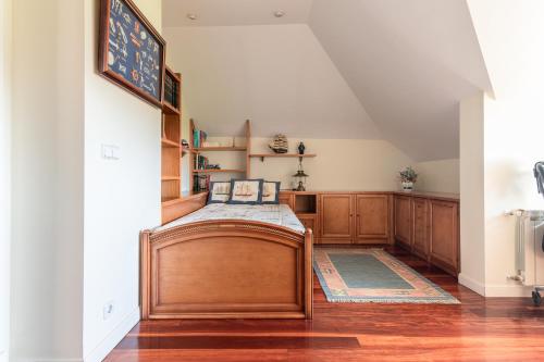 a bedroom with a wooden bed in a room at Villa entre Santander y Cabárceno con piscina in Revilla de Camargo