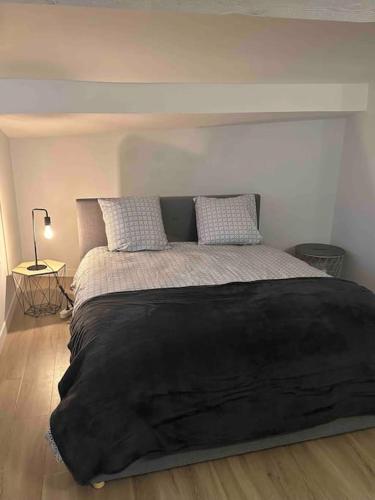 - une chambre avec un grand lit noir et deux oreillers dans l'établissement Entre Vignes et Mer, avec Wifi, Clim et Netflix, à Mireval