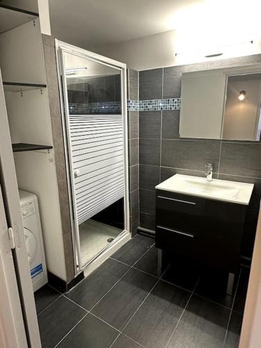 une salle de bain avec une douche, un lavabo et un miroir dans l'établissement Entre Vignes et Mer, avec Wifi, Clim et Netflix, à Mireval