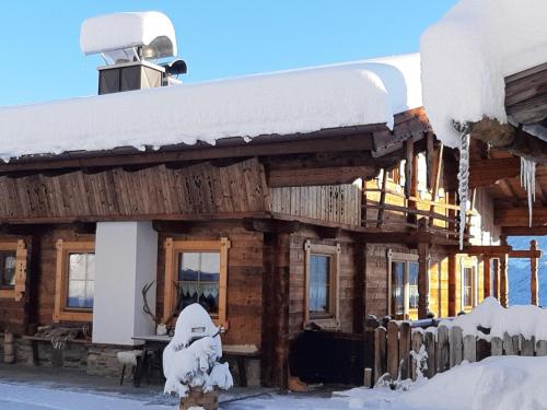 a log cabin with snow on the roof at Haus Wildschütz in Hippach