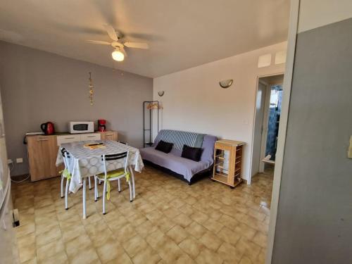 een woonkamer met een tafel en een bank bij Agréable Appartement in La Londe-les-Maures