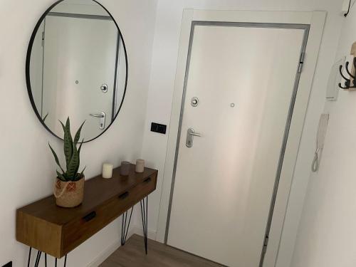 a bathroom with a mirror and a table with a plant at El mirador de Santa Justa in Orihuela