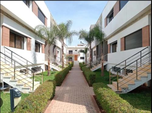 a walkway between two buildings with palm trees at testingg in Zemmour Touirza