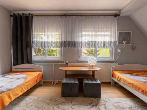 1 Schlafzimmer mit 2 Betten, einem Tisch und einem Fenster in der Unterkunft U Beaty in Ruciane-Nida
