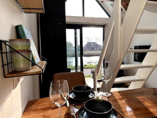 uma mesa de madeira com copos de vinho em cima em Tiny house of Picasso em Warmenhuizen