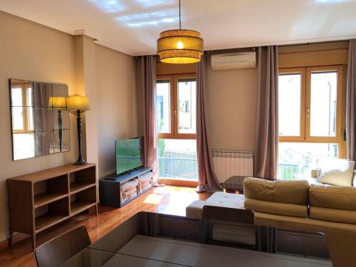 a living room with a couch and a television at Dúplex Sierpes centro parking in Salamanca