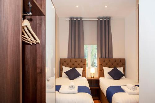um quarto com 2 camas e uma janela em Putera Puteri Residence em Londres