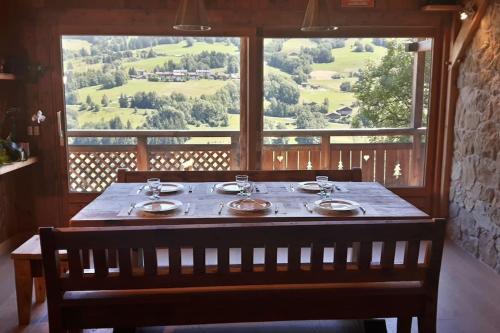 - une table dans une chambre avec une grande fenêtre dans l'établissement 2 spacieux appartements dans une ferme rénovée face au MontBlanc, à Megève